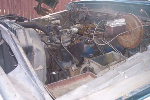 1977 Ford F-150 - The engine compartment of a vehicle shows its V8 engine, radiator, and various hoses and wires.