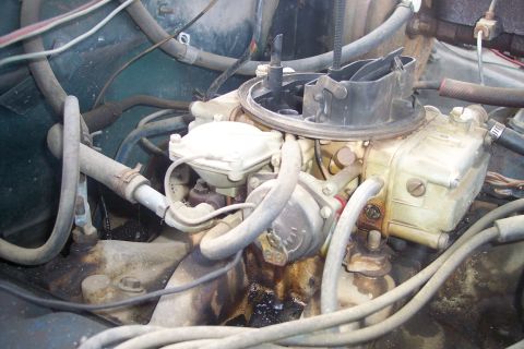 1977 Ford F-150 - Close-up view of an engine's carburetor, surrounded by various fuel lines and hoses.