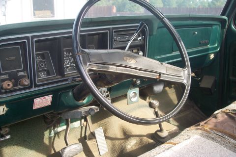 1977 Ford F-150 - The interior of a 1977 Ford F-150 shows its dashboard, steering wheel, and floor shifter.