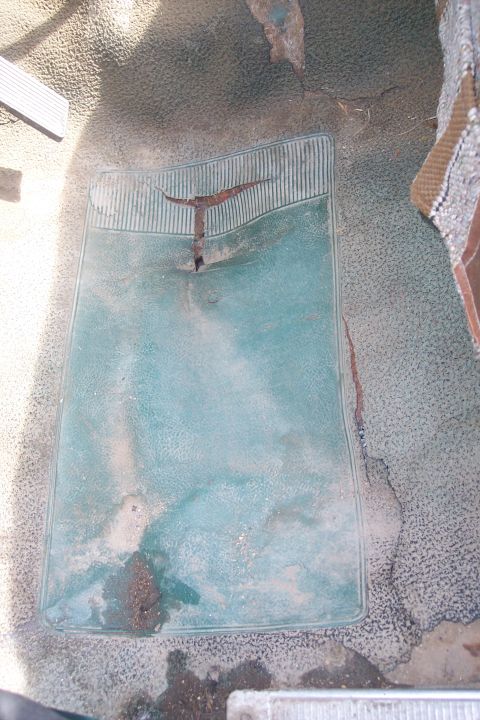 1977 Ford F-150 - The interior floor mat shows significant wear and tear, with rust visible on a metal component.
