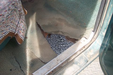 1977 Ford F-150 - The floor pan of this vehicle has rusted through, exposing the gravel beneath.