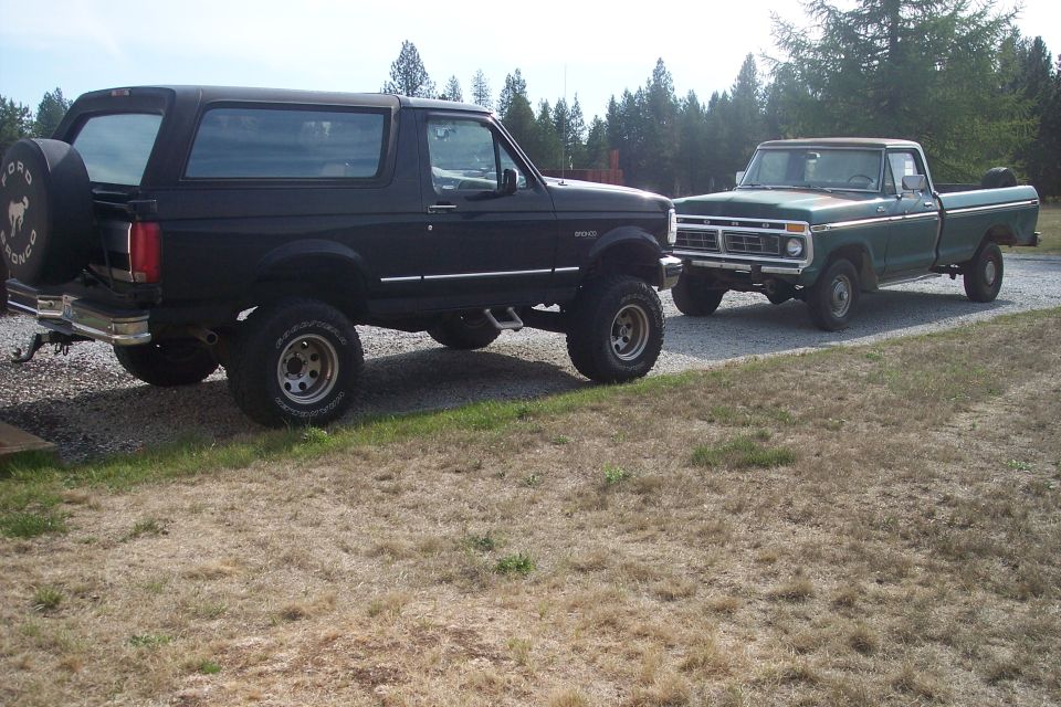 Black Ford Bronco and green Ford F-150 parked side-by-side