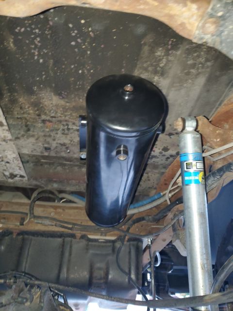 1996 Ford Bronco - Underside view of an aftermarket air tank and shock absorber installation.