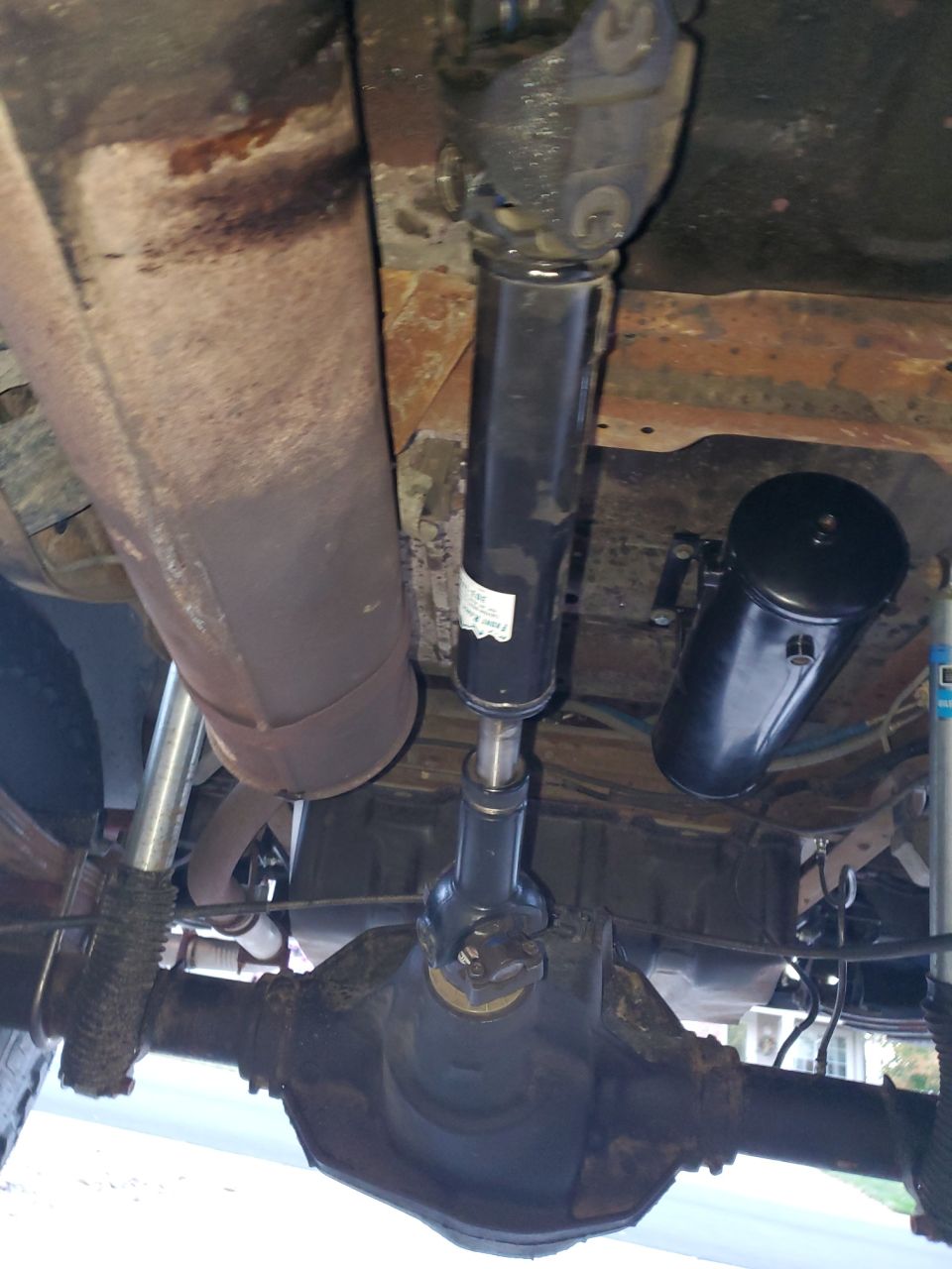 Underside view of driveshaft and differential with an air tank mounted