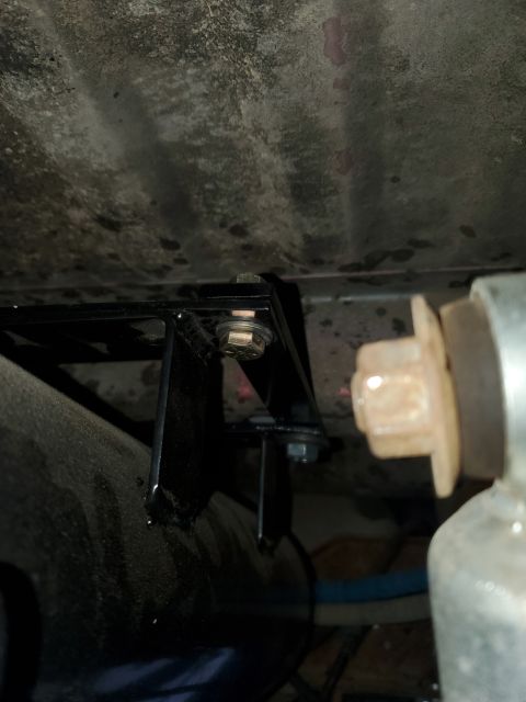 1996 Ford Bronco - Close-up of a metal bracket and fasteners mounted underneath a vehicle.