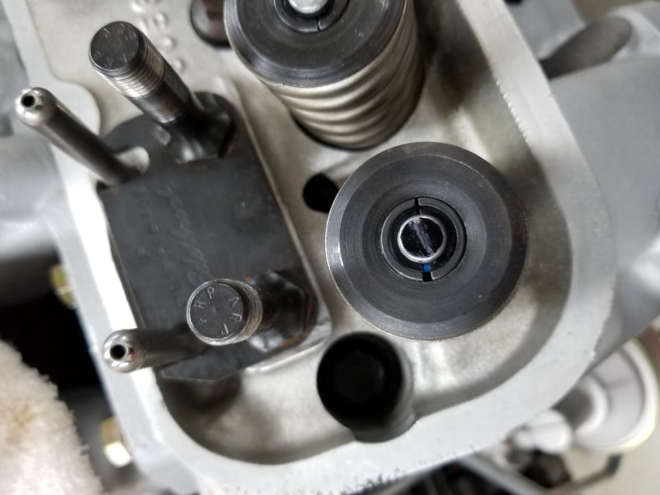 Close-up of engine valve train components, including a valve spring and rocker arm