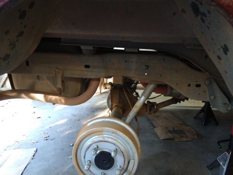 1996 Ford Bronco - The underside of a vehicle is shown, with the rear axle, differential, driveshaft, exhaust pipe, and fuel tank visible. A drum brake is pro…