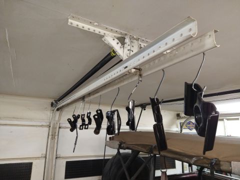 1996 Ford Bronco - Several black painted automotive parts are hanging from hooks on a track system mounted to a garage ceiling. The parts appear to be freshly…