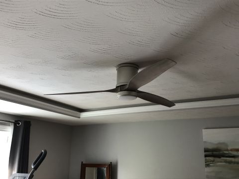 1995 Mercury Grand Marquis - A ceiling fan with wooden blades is mounted on a textured white ceiling. The fan is positioned in the center of a recessed ceiling with cro…