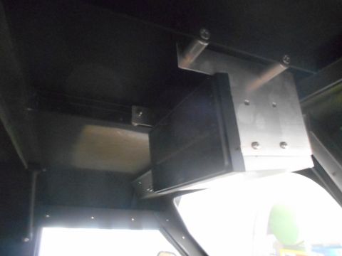 1992 Ford Bronco - A custom metal bracket is mounted to the interior ceiling of a vehicle, holding a black electronic device. The bracket appears to be made o…