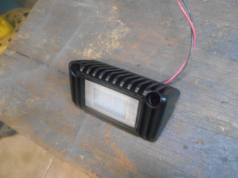 Black LED light with wires on a wooden surface