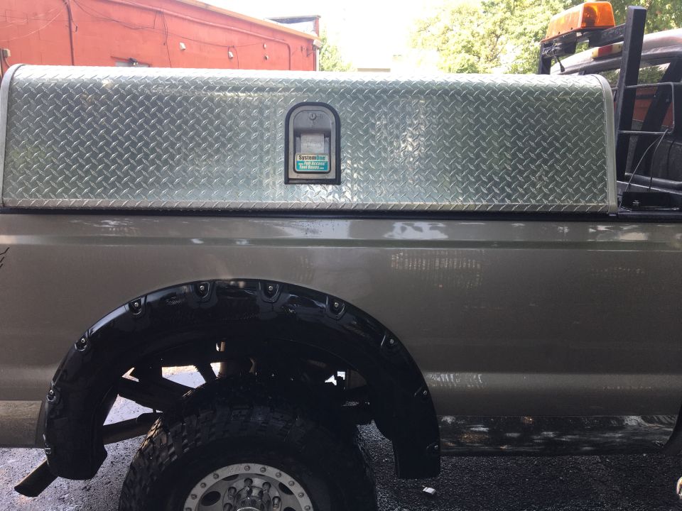 Diamond plate truck bed tool box and rear fender of a pickup truck.