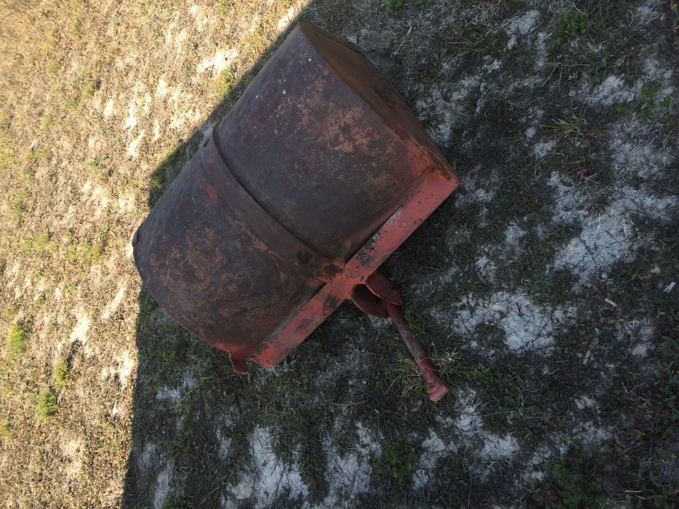 Rusty metal roller with red frame on the ground