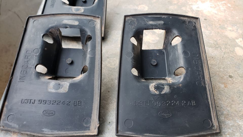 Two black Ford parts with part numbers D3TJ 9932242 BB and D3TJ 9932242 AB.