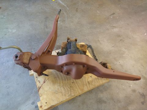 1996 Ford Bronco - A rusty brown differential housing with a single arm extending from the left side is mounted on a wooden pallet. A metal chain is visible w…