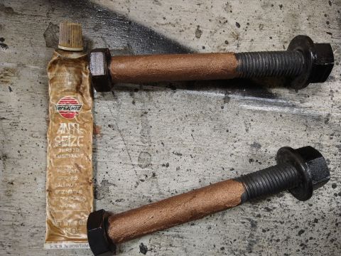 1996 Ford Bronco - A tube of Versachem Anti-Seize Thread Lubricant is shown next to two large bolts. The bolts have a copper-colored anti-seize compound appli…