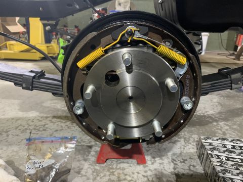 1979 Jeep CJ5 - A close-up view of the rear drum brake assembly of a 1979 Jeep CJ5, showing the brake shoes, springs, and hub. The vehicle is supported by…