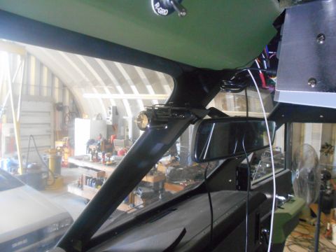 1992 Ford Bronco - Interior view of a vehicle's windshield area, showing a rearview mirror, wiring, and a light attached to the A-pillar. The background appea…