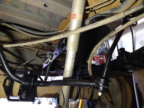 1996 Ford Bronco - The underside of a vehicle shows a close-up of the rear suspension system, including leaf springs, a shock absorber, and a sway bar. The co…