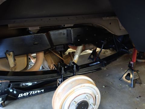 1996 Ford Bronco - The undercarriage of a vehicle is shown, with a focus on the rear suspension system including leaf springs, U-bolts, and a drum brake assem…