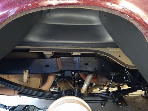 1996 Ford Bronco - The underside of a vehicle's rear wheel well and suspension system is shown, featuring leaf springs, a shock absorber, and the frame. The v…