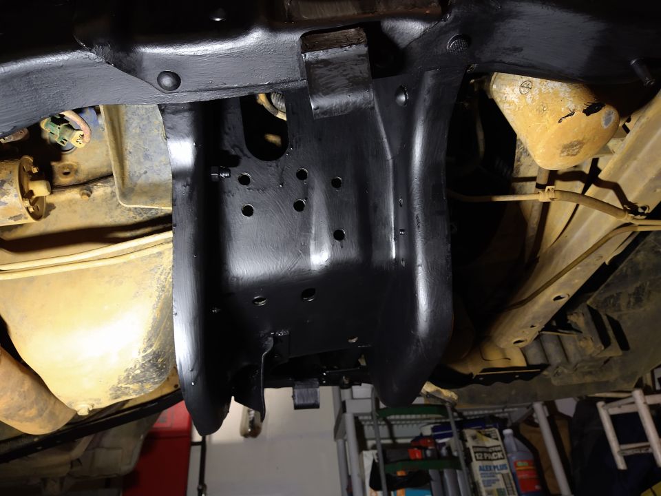 Underside of a vehicle with a black painted metal part.