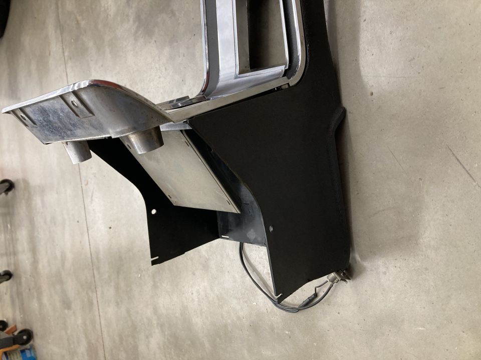 Black and chrome automotive center console part with exhaust tips