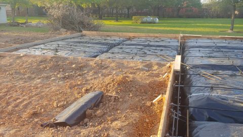 1995 Ford Bronco - A construction site shows rebar and plastic sheeting prepared for a concrete foundation pour.