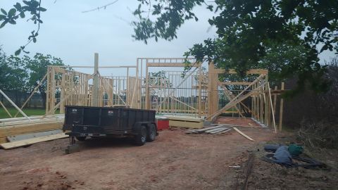 1995 Ford Bronco - Construction site with a trailer and the wooden frame of a house under a cloudy sky.