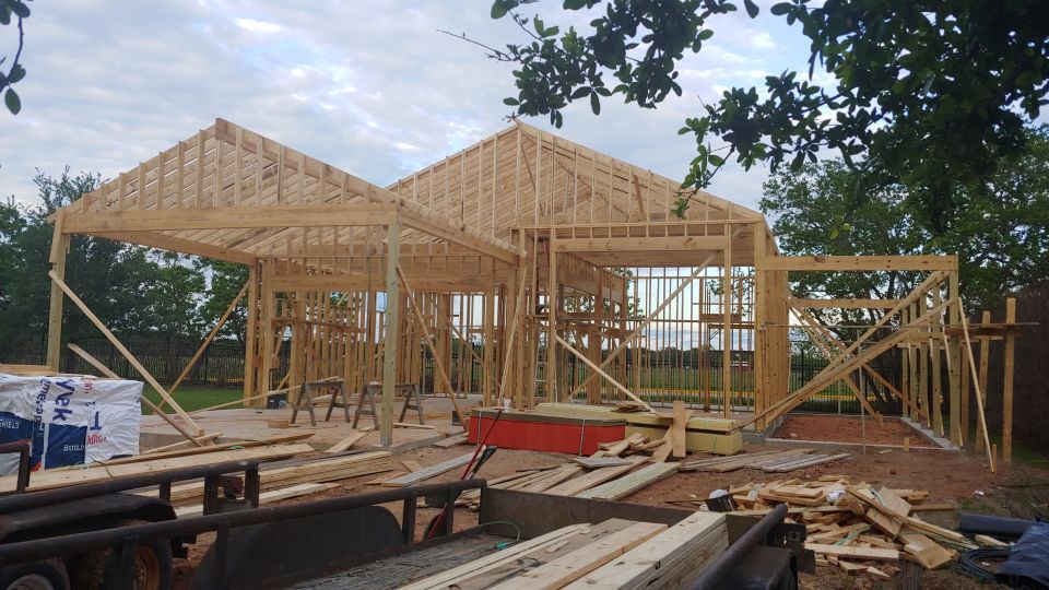 Wood framing for a house under construction, with lumber and building materials visible