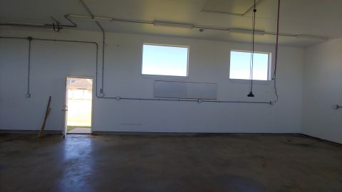 1995 Ford Bronco - Empty garage interior with concrete floor, white walls, and fluorescent lighting.