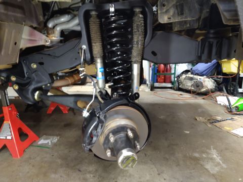 1996 Ford Bronco - The vehicle's front suspension and drivetrain are exposed, showing disassembled components and suspension upgrades.