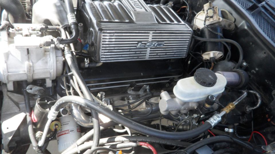 Close-up of a car engine bay with a polished LSC intake manifold.