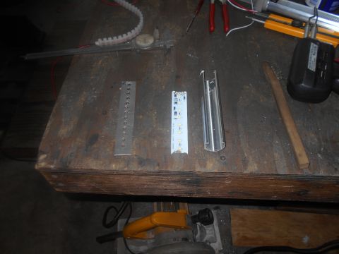 1992 Ford Bronco - A workbench with various tools and components, including a metal ruler, an LED strip, a metal channel, a wire brush, and a soldering iron.