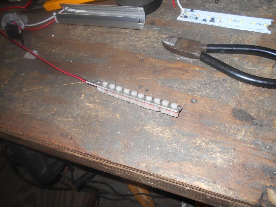 Workbench with LED strips, wires, switch, and wire cutters.