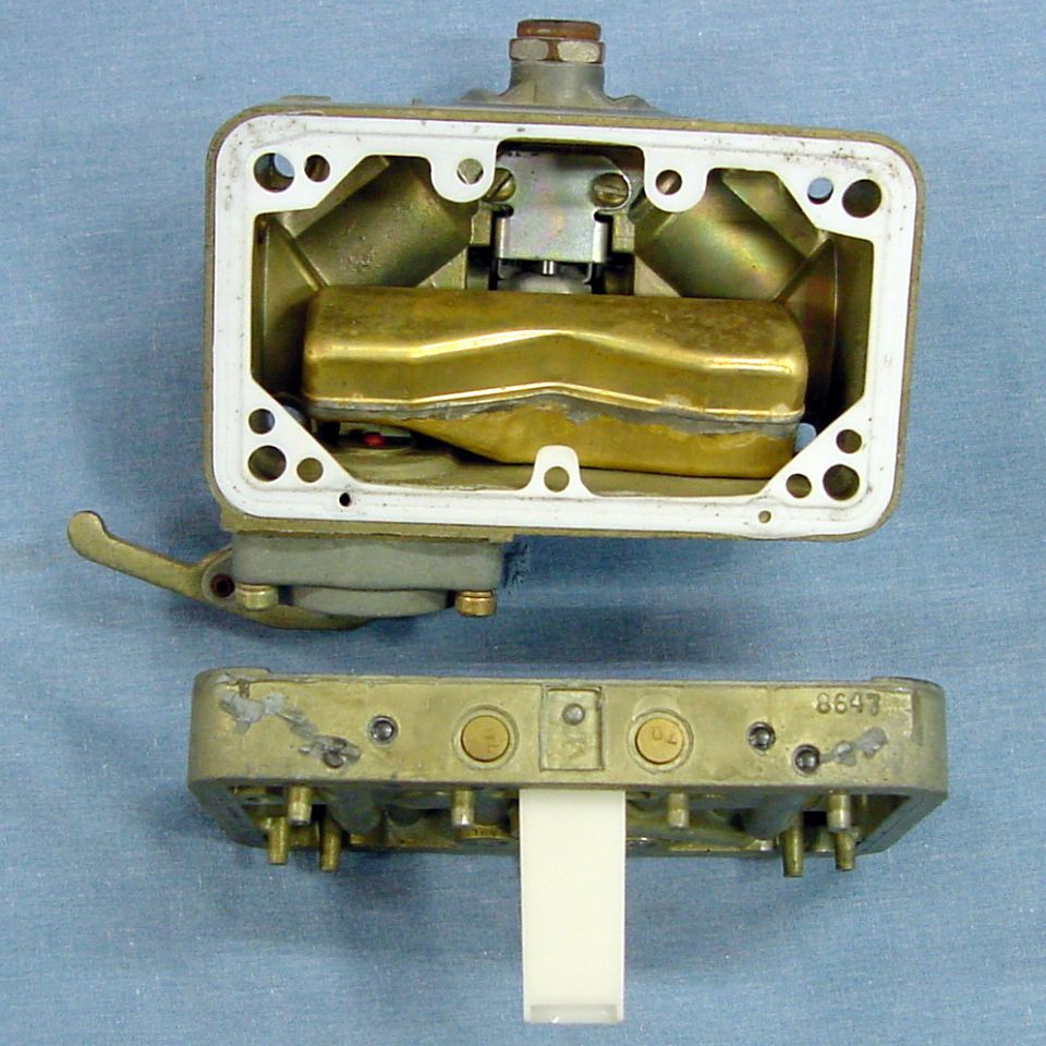 Disassembled carburetor with brass float and jets.