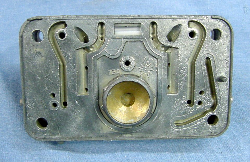 Carburetor base with internal channels and brass fitting, marked 13A.