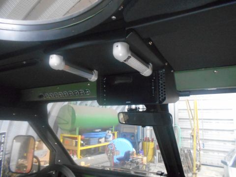 1992 Ford Bronco - Interior view of a vehicle's overhead console featuring two white LED lights and a black control unit with multiple buttons. A green panel…