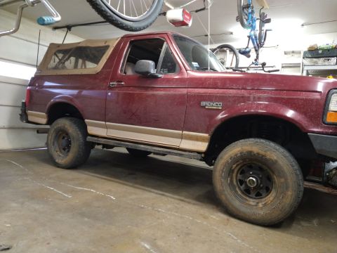 1996 Ford Bronco - This maroon Ford Bronco is parked indoors with bicycles hanging from the ceiling.