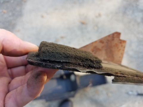 1976 Ford Ranchero - A dirty foam part, possibly from a heaterbox, is held by a hand against a blurred background.