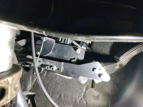 2010 Ford F-250 - Close-up of an aftermarket brake controller bracket installed in a vehicle's footwell.