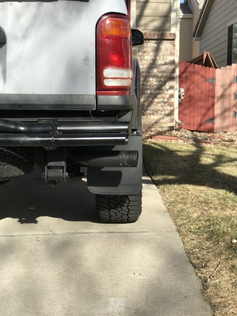 2000 Ford Explorer - Rear view of a white 2000 Ford Explorer, showing the bumper, tire, and mud flap.