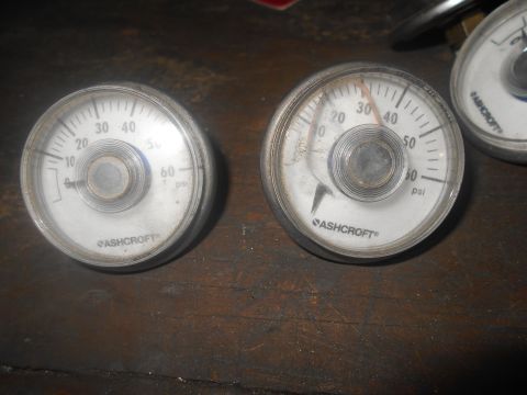 1992 Ford Bronco - Close-up of two Ashcroft pressure gauges, showing different readings on a wooden background.