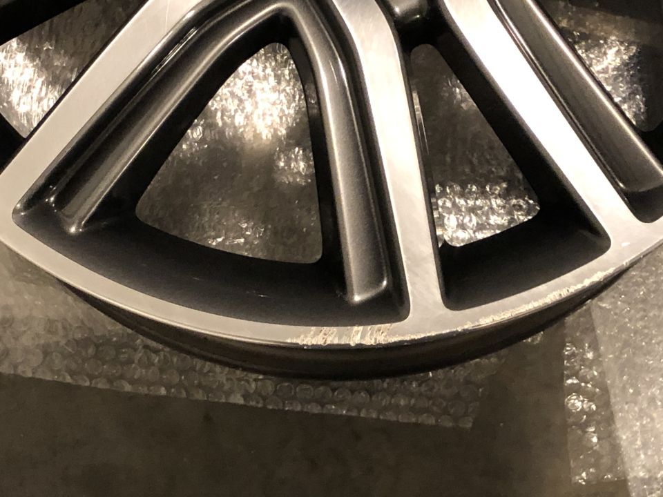 Close-up of a damaged alloy wheel rim with scuff marks on the edge