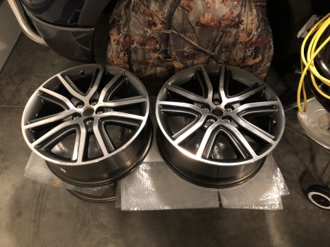 2019 Ford Everest - Two alloy wheels are shown, resting on bubble wrap, with a portion of a vehicle and camouflage fabric in the background.