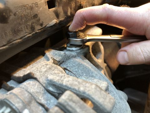 2019 Ford Everest - Hand using a wrench on a bolt. Text is visible on a black plastic part.