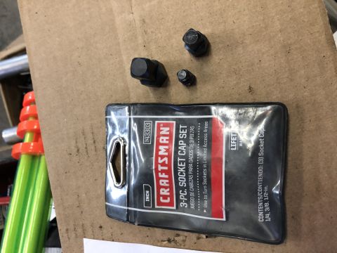 2019 Ford Everest - A Craftsman socket cap set and three lug nuts are laid out on a brown surface.