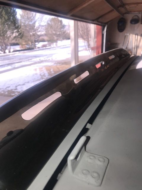 2000 Ford Explorer - Close-up of a black roof rack rail with distinctive cutouts, seen from an angled perspective.