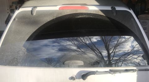 2000 Ford Explorer - Rear view of a dusty 2000 Ford Explorer, showing reflection in the window.