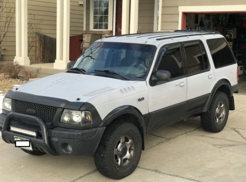2000 Ford Explorer - This SUV features a two-tone paint scheme and aftermarket modifications like a light bar and off-road tires.